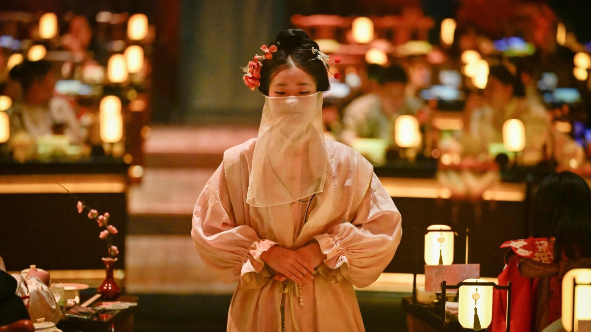 A waitress in traditional Chinese clothes waits to serve customers at a theatrical restaurant, Beijing, China, Nov. 5, 2025. (AFP Photo)