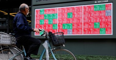 A man looks at a stock quotation board displaying the Nikkei share average outside a brokerage in Tokyo, Japan, Oct. 21, 2025. (Reuters Photo)