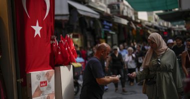 A seller talks to a customer in a street market in Istanbul, Türkiye, Sept. 6, 2023. (AP Photo)