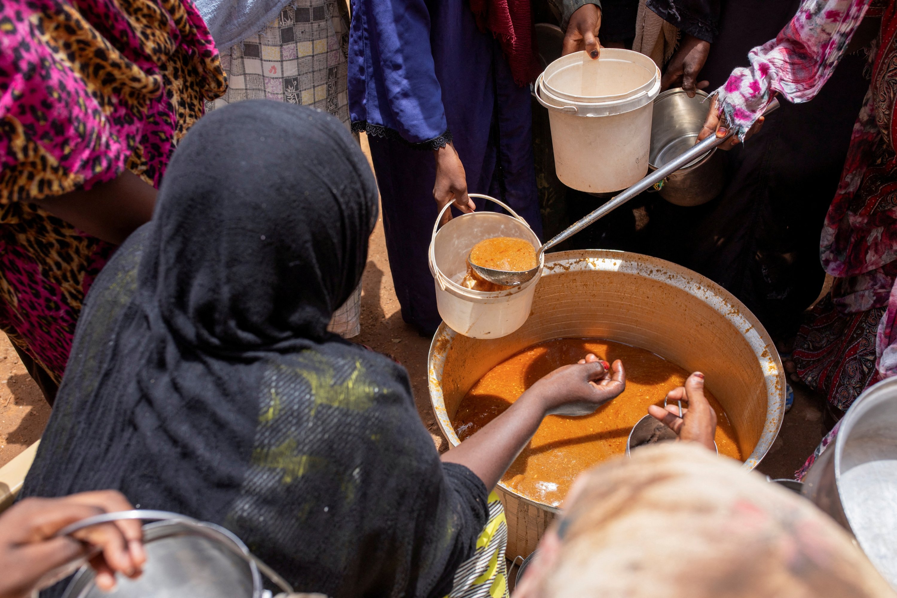 Sudanese women from community kitchens run by local volunteers distribute meals to people affected by conflict and extreme hunger, Omdurman, Sudan, July 27, 2024. (Reuters Photo)
