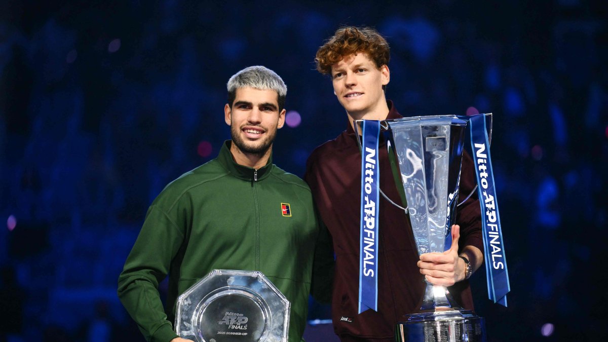 Italy's Jannik Sinner (R) and Spain's Carlos Alcaraz pose with their trophies at the end of the men's single final match at the ATP Finals tennis tournament, Turin, Italy, Nov. 16, 2025. (AFP Photo)