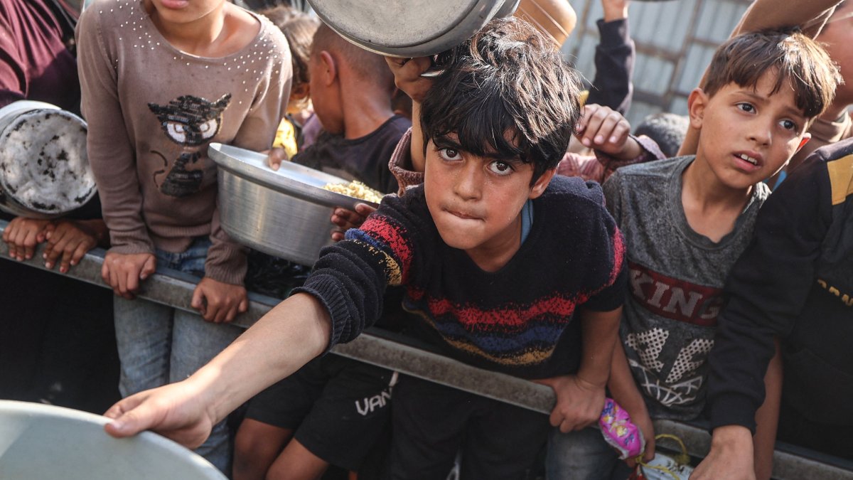 Young Palestinians wait with their containers to receive a portion of food in the Nuseirat refugee camp, in central Gaza Strip, Palestine, Nov. 10, 2025. (AFP Photo)