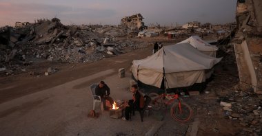 Palestinians sit next to a fire, amid a cease-fire between Israel and Hamas, in Gaza City, Palestine, Nov. 17, 2025. (Reuters Photo)