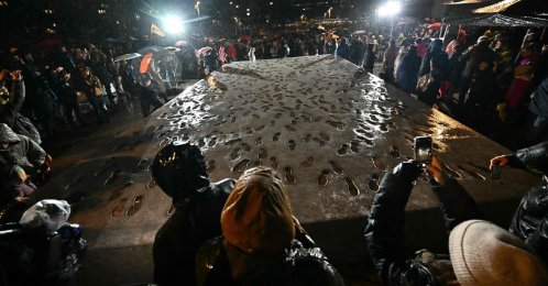 Demonstrators stand around a memorial commemorating the events of the Velvet Revolution as it is unveiled in Bratislava, Slovakia, Nov. 17, 2025. (AFP Photo)