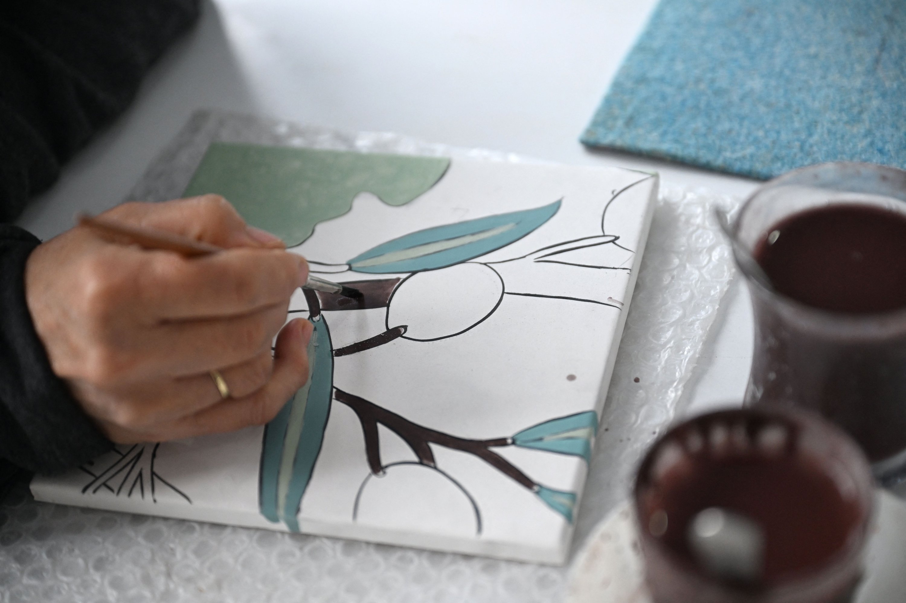 Una mujer pinta un azulejo en un taller en Iznik, Bursa, Türkiye, el 14 de octubre de 2025. (Foto AFP)