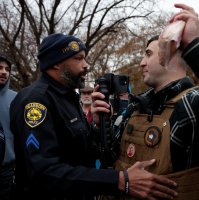 A Dearborn Police Officer confronts far-right activist Jake Lang, as he waves a package of bacon during a protest against Islam in Dearborn, Michigan, U.S. Nov. 18, 2025. (Reuters Photo)