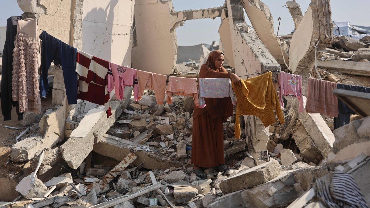 A Palestinian woman hangs clothes to dry amid the ruins of a building in Gaza City, Palestine, Nov. 18, 2025. (AFP Photo)