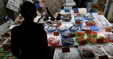 A customer looks around seafood at a shop in Tokyo, Japan, Nov. 19, 2025. (Reuters Photo)