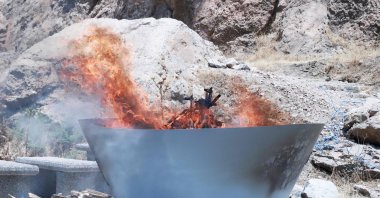 A pit filled with weapons is set on fire during a disarmament ceremony by the PKK, Sulaimaniyah, Iraq, July 11, 2025. (AFP Photo)