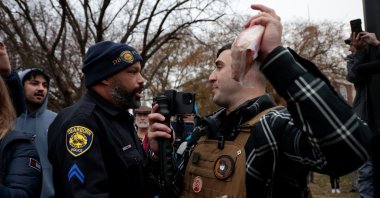 A Dearborn Police Officer confronts far-right activist Jake Lang, as he waves a package of bacon during a protest against Islam in Dearborn, Michigan, U.S. Nov. 18, 2025. (Reuters Photo)
