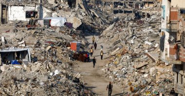 Palestinians walk among piles of rubble and damaged buildings in the northern Gaza Strip, Nov. 19, 2025. (Reuters Photo)