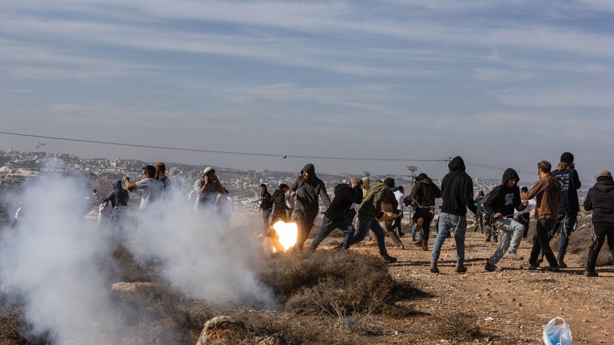 Radical Israeli terrorist group Hilltop Youth run for cover as they clash with Israeli security forces evacuating and demolishing an illegal outpost built near the Jewish settlement of Metzad east of the Palestinian city of Sa’ir in the occupied West Bank, Nov. 17, 2025. (AFP Photo)