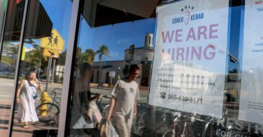 A "We&#039;re Hiring" sign hangs on a window of a restaurant in Miami, Florida, U.S., Nov. 19, 2025. (AFP Photo)