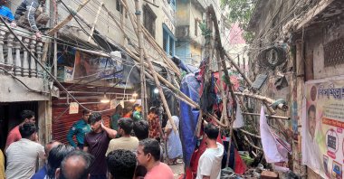 Residents stand in an alley after vacating their house next to a fallen scaffolding following an earthquake, Dhaka, Bangladesh, Nov. 21, 2025. (Reuters Photo)