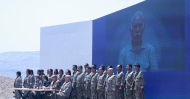 PKK terrorists stand in front of a picture of jailed leader and founder of the PKK Abdullah Öcalan during a disarmament ceremony, Sulaimaniyah, Iraq, July 11, 2025. (AFP Photo)