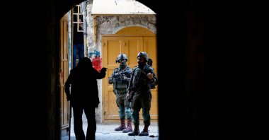 A Palestinian argues with Israeli troops as they stand guard during a weekly settlers&#039; tour in Hebron, West Bank, occupied Palestine, Nov. 22, 2025. (Reuters Photo)