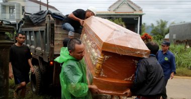 Men unload a coffin from a truck ahead of a funeral for a person who died in the floods in Hoa Thinh commune, Dak Lak province, central Vietnam, Nov. 22, 2025. (AFP Photo)