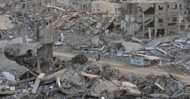 Palestinian women walk among piles of rubble and damaged buildings, Gaza, Palestine, Nov. 24, 2025. (Reuters Photo)