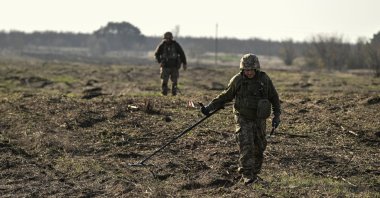 Ukrainian soldiers use metal detectors to search for explosive devices during demining a field, Kherson, Ukraine, Nov. 22, 2025. (Reuters Photo)
