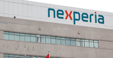 Flags fly next to a logo of Nexperia at the facade of its factory amidst a shortage of chip supply caused by a diplomatic standoff between China and the Netherlands over the company, in Dongguan, Guangdong province, China, Nov. 7, 2025. (Reuters Photo)