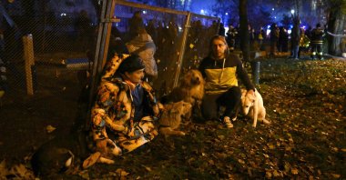 Residents stand outside after evacuating a damaged residential building following Russian missiles and drones strikes in Kyiv, Ukraine, Nov. 25, 2025. (AFP Photo)