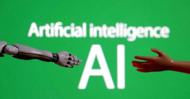 Words reading &quot;Artificial intelligence AI,&quot; a miniature robot and a toy hand are pictured in this illustration, Dec. 14, 2023. (Reuters Photo)