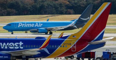 An Amazon plane taxis as a Southwest Airlines passenger plane is seen in the foreground at Baltimore Washington International Airport in Baltimore, Maryland, U.S.,  Nov. 10, 2025. (AFP Photo)