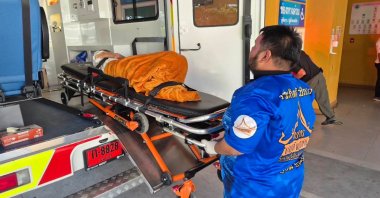 An emergency rescue team transports a presumed-dead elderly woman discovered to still be alive before her scheduled cremation at Wat Rat Prakhong Tham temple, Nonthaburi province, Thailand, Nov. 23, 2025. (AP Photo)