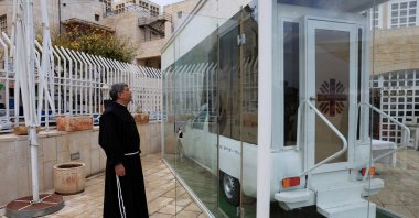 Father Ibrahim Faltas, a Franciscan friar of the Custody of the Holy Land, looks at the Vehicle of Hope, the former popemobile used by Pope Francis which has been transformed into a fully equipped mobile clinic, in Bethlehem in the Israeli-occupied West Bank, Nov. 25, 2025. (Reuters Photo)