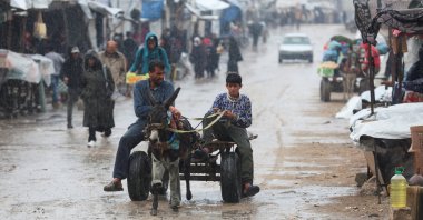 Palestinians ride a donkey-pulled cart during a rainy day in Khan Younis in the southern Gaza Strip, Nov. 25, 2025. (Reuters Photo)