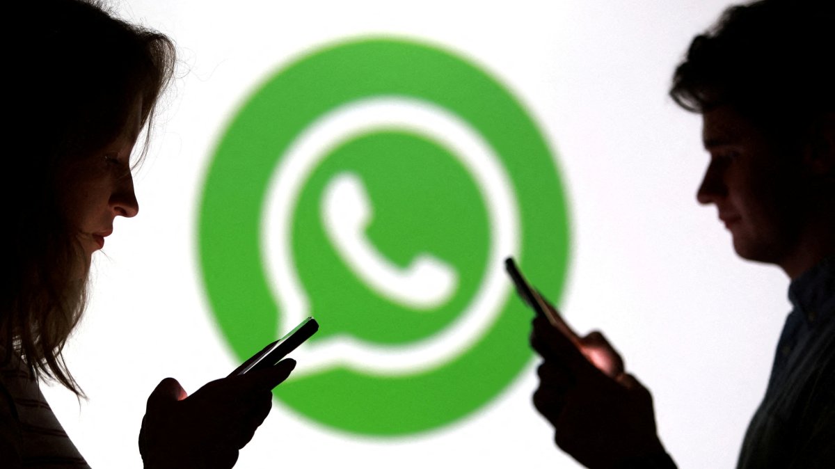 Teenagers pose for a photo while holding smartphones in front of a WhatsApp logo in this illustration taken Sept. 11, 2025. (Reuters Photo)