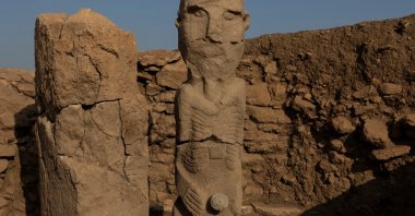 A pillar and a human statue stand at the Karahantepe excavation site, widely regarded with Göbeklitepe as keys to understanding the birth of symbolic thought, social complexity and monumental architecture thousands of years before cities or states existed, near the southeastern city of Şanlıurfa, Türkiye, Nov. 25, 2025. (Reuters Photo)