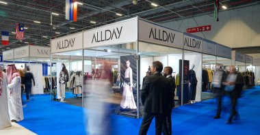 People pass next to a booth at the World Halal Summit and Halal Expo, Istanbul, Türkiye, Nov. 26, 2025. (AA Photo)