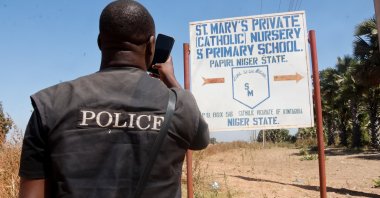 A member of the security forces takes photos of St. Mary&#039;s Private Catholic School signage after 303 pupils kidnapped, in Papiri, Niger State, Nigeria, Nov. 24, 2025. (EPA Photo)