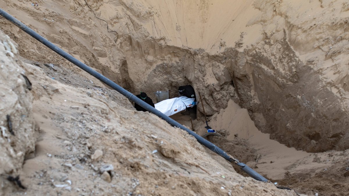 Hamas fighters carry a white bag containing a body after retrieving it from a tunnel in Khan Younis, southern Gaza, Oct. 28, 2025. (EPA Photo)