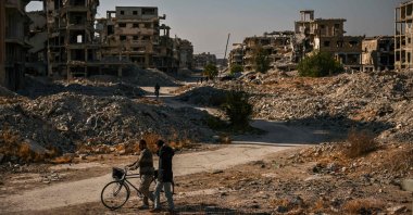 Two men walk past the rubble of destroyed and damaged buildings at the Yarmuk refugee camp, south of Damascus, Syria, Dec. 14, 2024. (AFP Photo)