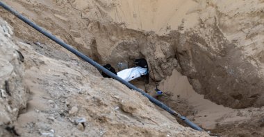 Hamas fighters carry a white bag containing a body after retrieving it from a tunnel in Khan Younis, southern Gaza, Oct. 28, 2025. (EPA Photo)