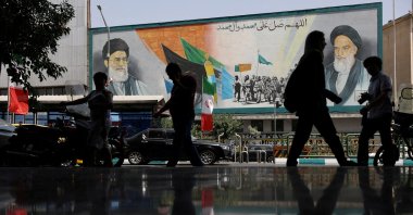 People walk next to a mural with a picture of Iran&#039;s Supreme Leader, Ayatollah Ali Khamenei, on a street, early hours of ceasefire, in Tehran, Iran, June 24, 2025. (Reuters File Photo)