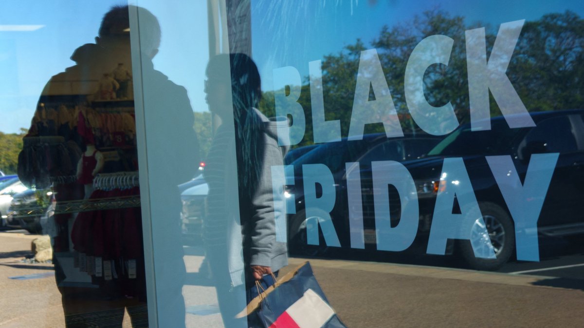 Shoppers are reflected on glass as a Black Friday sale sign is displayed at an outlet mall in Carlsbad, California, U.S., Nov. 25, 2025. (Reuters Photo)