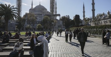 People walk in the historic Fatih district with the iconic Sultanahmet Mosque, or Blue Mosque, in the background, Istanbul, Türkiye, Nov. 25, 2025. (EPA Photo)