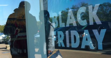 Shoppers are reflected on glass as a Black Friday sale sign is displayed at an outlet mall in Carlsbad, California, U.S., Nov. 25, 2025. (Reuters Photo)