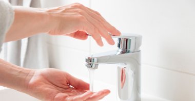 A person washing hands efficiently by turning off the tap during lathering. (Shutterstock Photo)