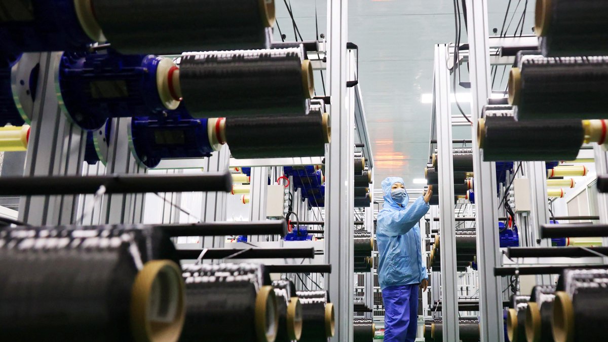A worker checks carbon fiber in the production line at a bicycle factory in Lianyungang, China, Nov. 14, 2025. (AFP Photo)