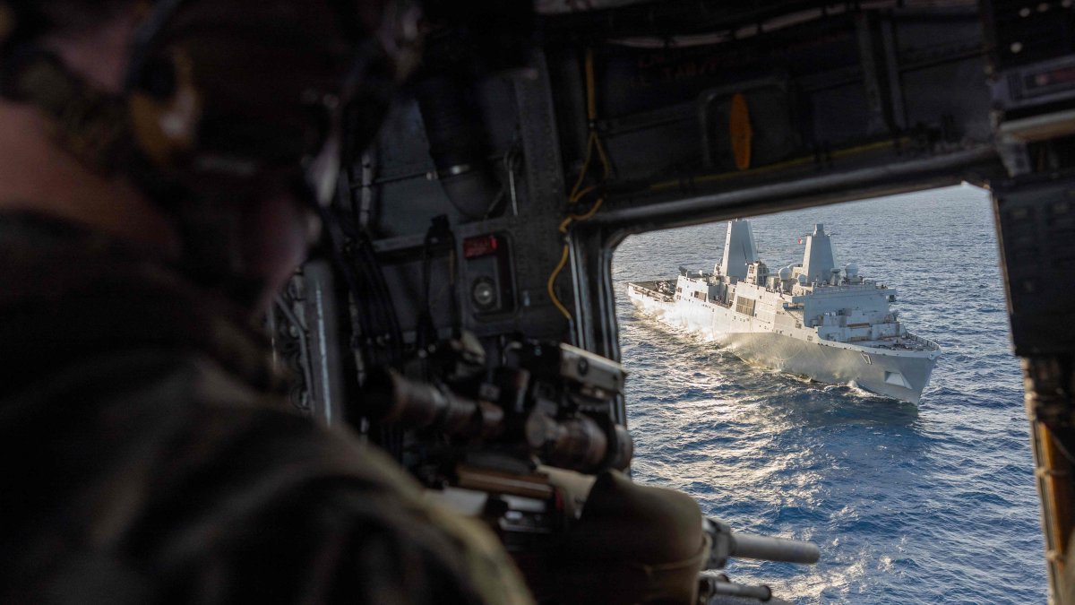 A U.S. Marine with the Maritime Special Purpose Force, 22nd Marine Expeditionary Unit, provides aerial sniper support from a CH-53E Super Stallion helicopter during insertion training aboard the USS San Antonio in the Caribbean Sea, Nov. 25, 2025. (AFP Photo)