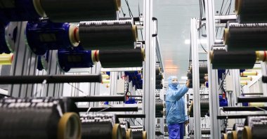 A worker checks carbon fiber in the production line at a bicycle factory in Lianyungang, China, Nov. 14, 2025. (AFP Photo)