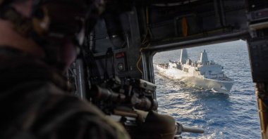A U.S. Marine with the Maritime Special Purpose Force, 22nd Marine Expeditionary Unit, provides aerial sniper support from a CH-53E Super Stallion helicopter during insertion training aboard the USS San Antonio in the Caribbean Sea, Nov. 25, 2025. (AFP Photo)