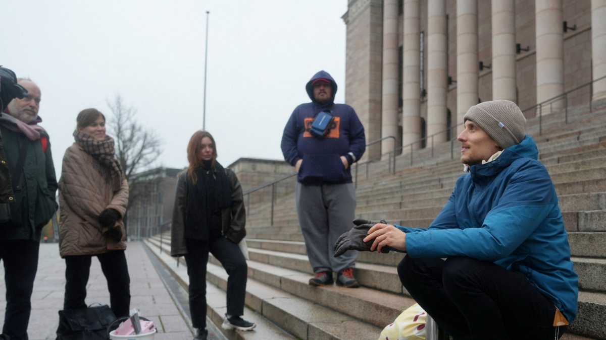 Juho-Pekka Palomaa, 33, sits on the steps in front of the Finnish parliament, where he was holding a potluck protest to mark 1,000 days of unemployment, Helsinki, Finland, Oct. 30, 2025. (Reuters Photo)