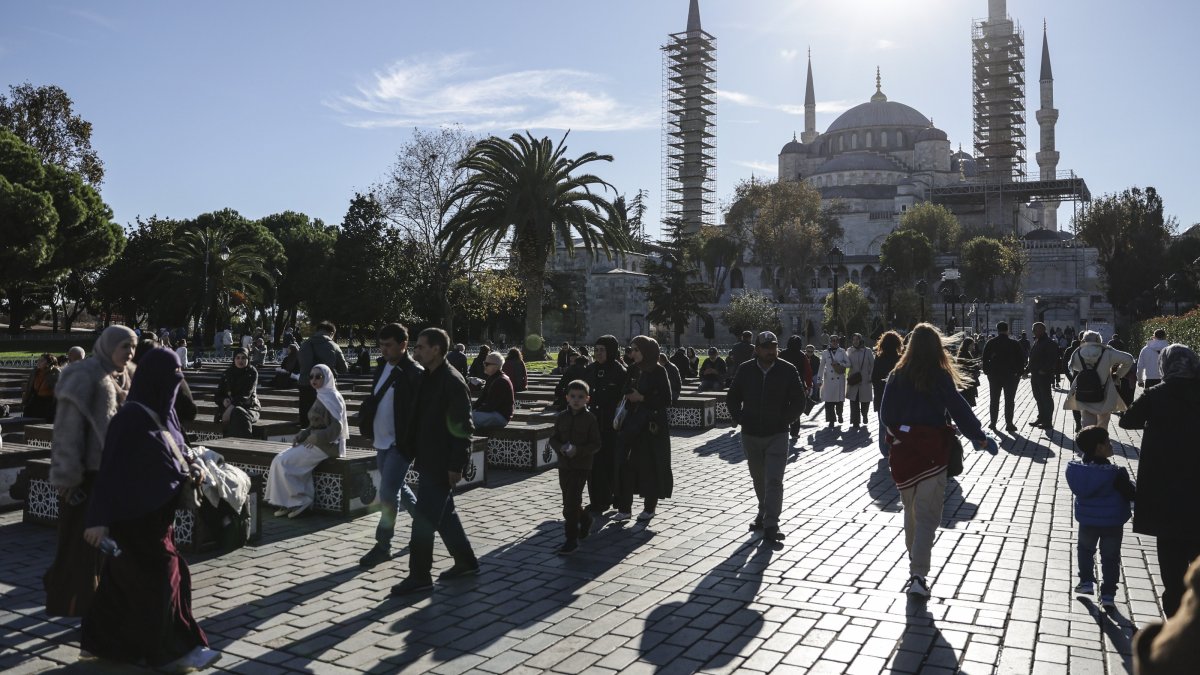 People walk in the historic Fatih district with the iconic Sultahmet Mosque, or Blue Mosque, in the background, Istanbul, Türkiye, Nov. 25, 2025. (EPA Photo) 