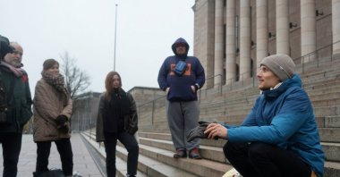 Juho-Pekka Palomaa, 33, sits on the steps in front of the Finnish parliament, where he was holding a potluck protest to mark 1,000 days of unemployment, Helsinki, Finland, Oct. 30, 2025. (Reuters Photo)