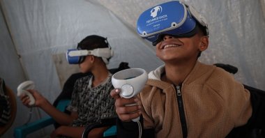 Palestinian children wearing goggles and holding a joy stick experience virtual reality as a medical technology support team launches an initiative in the city of al-Zawayda, central Gaza Strip, Palestine, Nov. 30, 2025. (AFP Photo)